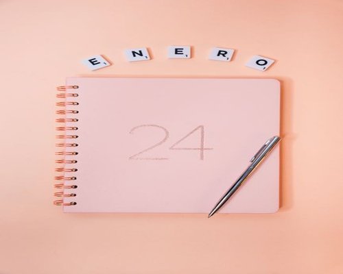 Mujer escribiendo en una agenda en la mesa de su sala en Alajuela